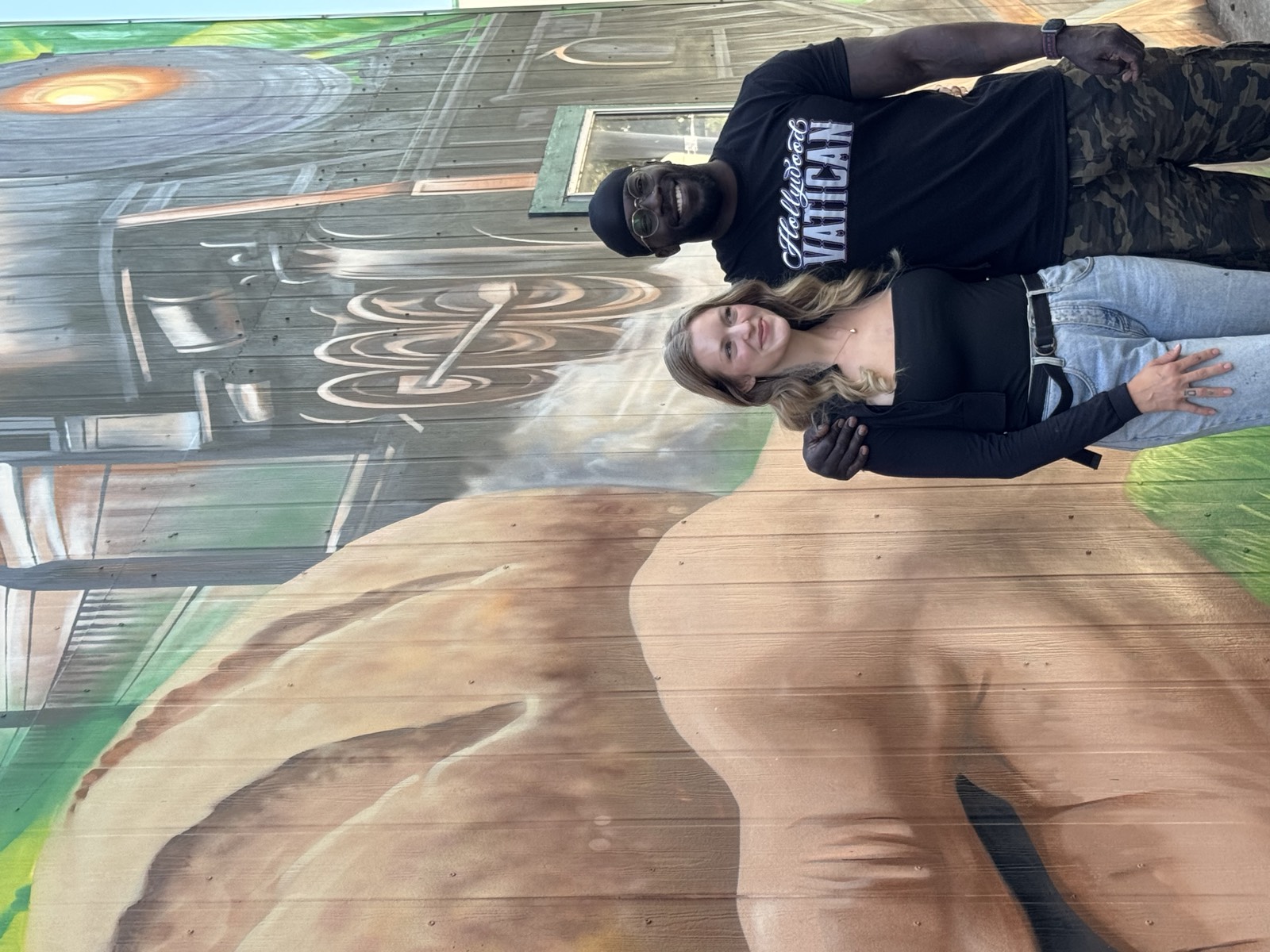 Joseph Bwire and Emily Compton-Bwire in front of their completed Columbia County Sesquicentennial mural in Dayton, Washington