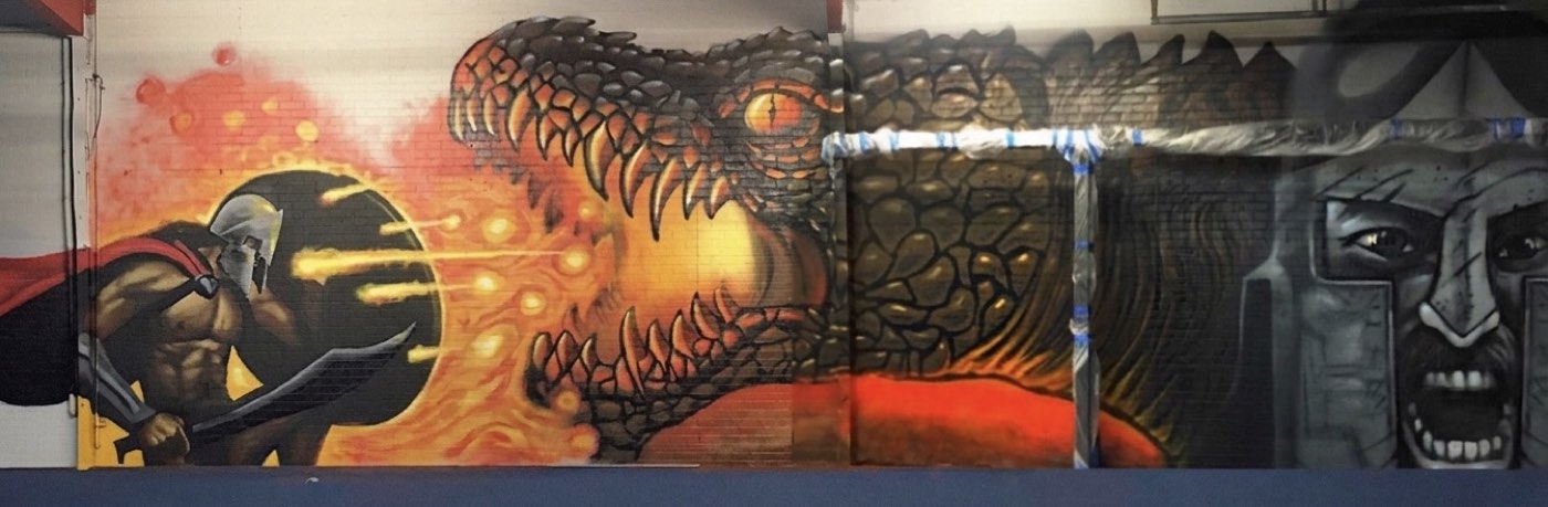 Spartan warrior facing a fire-breathing dragon painted across the training wall at OC Fit in Lake Forest, California
